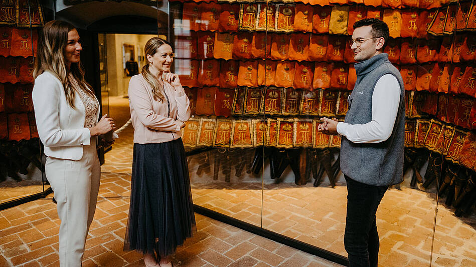 [Translate to Spanisch:] Tourguide mit 2 Gästen in den Innenräumen der Burg Forchtenstein